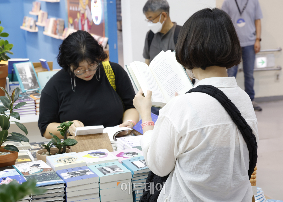 ▲14일 서울 강남구 코엑스에서 열린 '2023 서울국제도서전'을 찾은 관람객들이 책을 살펴보고 있다. 조현호 기자 hyunho@