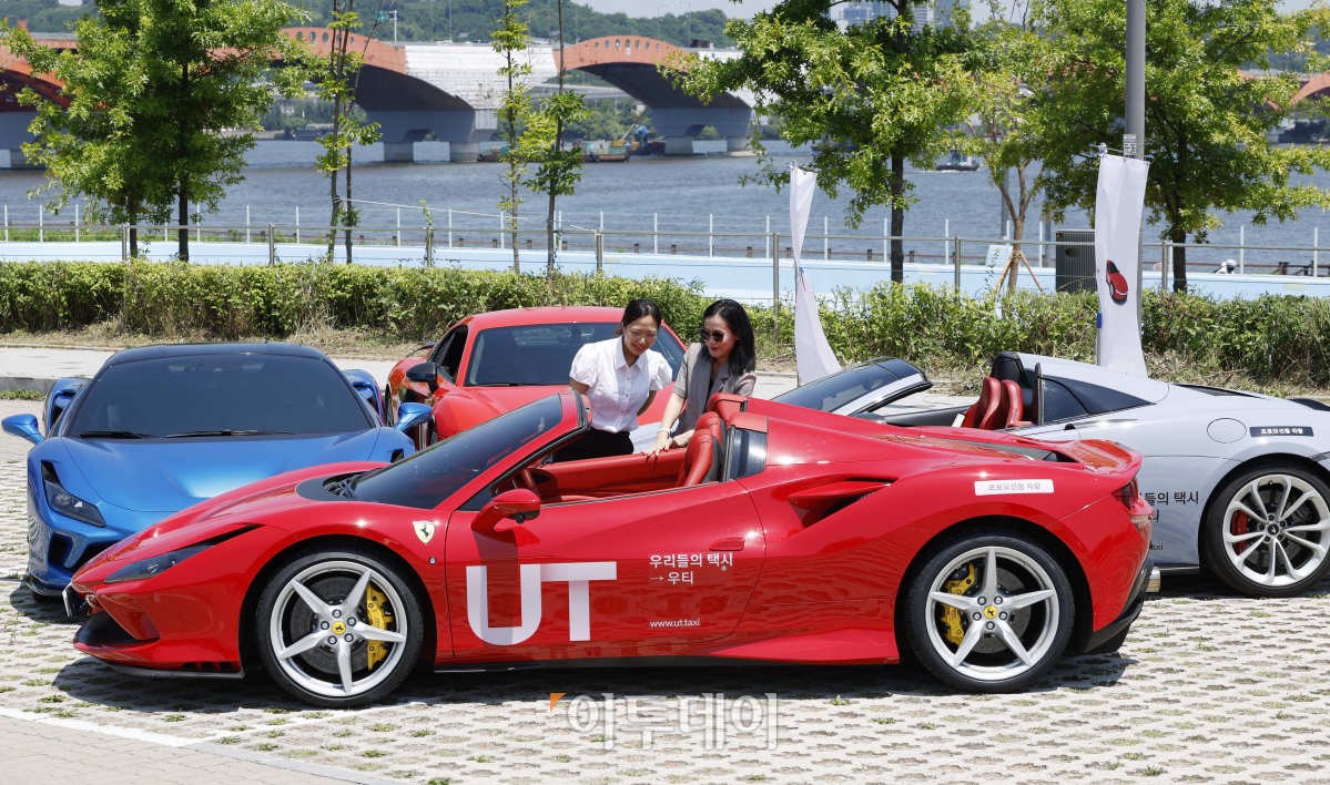 ▲16일 서울 영등포구 양화한강공원에서 열린 'UT(우리들의 택시) 슈퍼카와 함께하는 도심 드라이브' 사전공개 행사에서 시민들이 슈퍼카를 살펴보고 있다. UT 슈퍼카와 함께하는 도심 드라이브 이벤트는 우티가 제공하는 차별화된 승차 경험을 위해 마련된 이벤트다. 이용자들은 페라리, 멕라렌, 아우디 등 슈퍼카를 호출해 서울 도심 드라이브를 즐길 수 있다. 행사는 17일 하루동안 서울 전 지역에서 우티 앱을 통해 'UT 슈퍼카' 옵션을 호출해 이용할 수 있고 이용 요금은 무료다. 조현호 기자 hyunho@