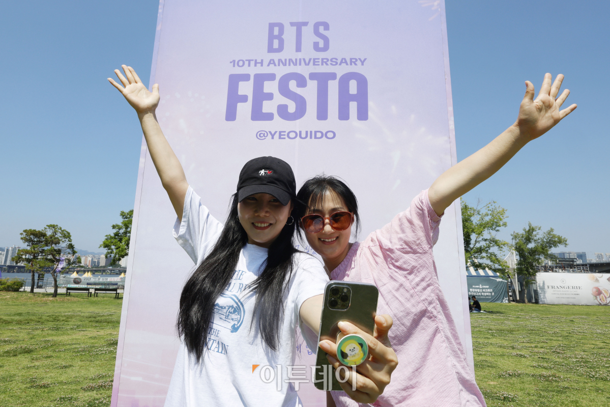 ▲방탄소년단(BTS) 10주년 페스타(FESTA)를 하루 앞둔 16일 오후 서울 영등포구 여의도한강공원에 설치된 방탄소년단 10주년 페스타 포토존 앞에서 시민들이 셀카를 찍고 있다. 조현호 기자 hyunho@