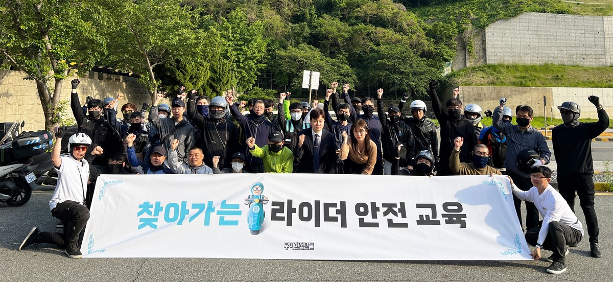 ▲우아한청년들이 지난달 17일 부산남부운전면허시험장에서 도로교통공단 부산지부와 함께 배달 이륜차 사고 예방을 위한 ‘부산지역 찾아가는 라이더 안전교육’을 시행했다. 참석자들이 모여 기념 촬영하고 있다. (사진제공=우아한청년들)