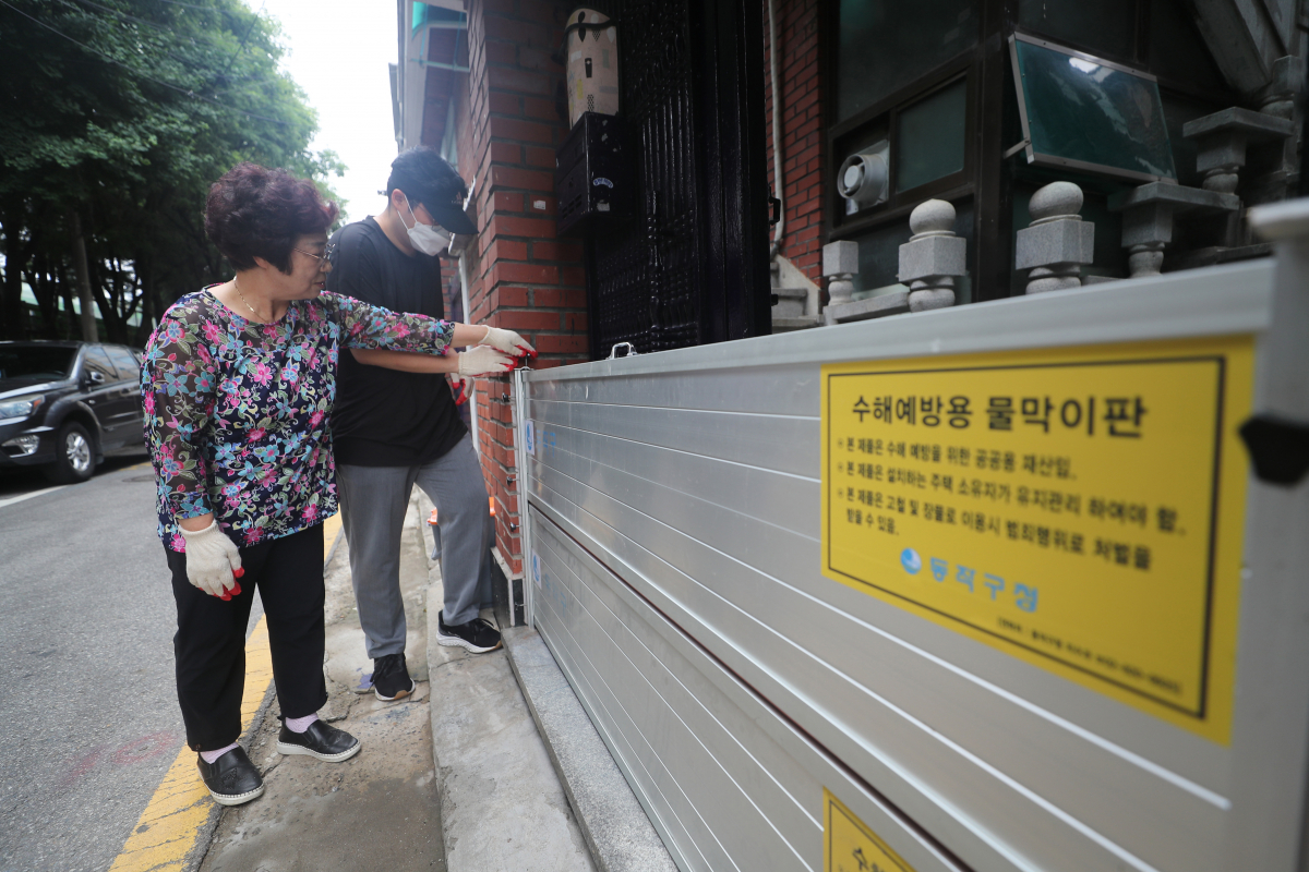 ▲본격적인 장마를 앞둔 23일 서울 동작구 도림천 인근 저지대 주택가에서 동작구청 관계자들이 설치된 수해예방용 물막이판을 점검하고 있다. 신태현 기자 holjjak@