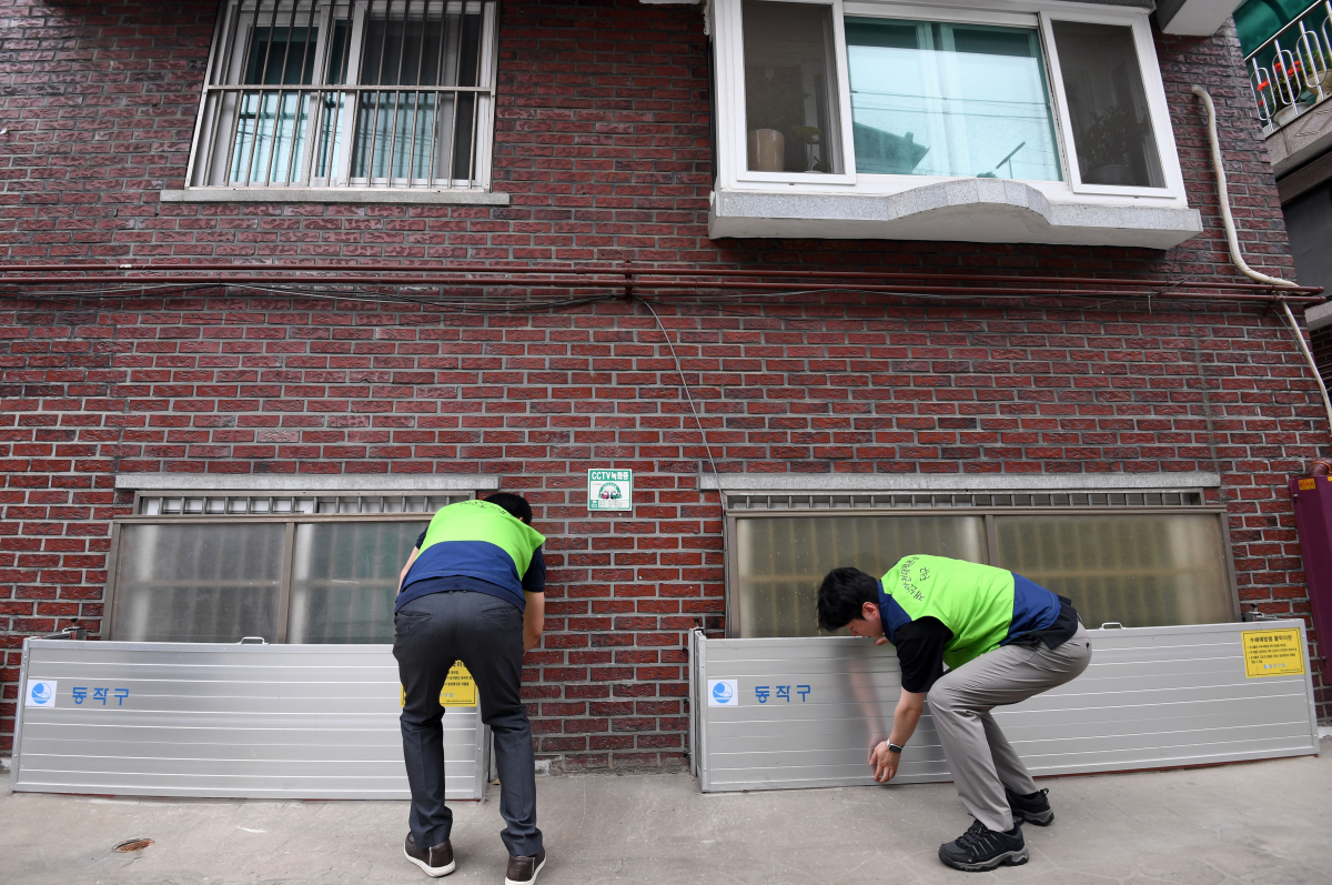 ▲본격적인 장마를 앞둔 23일 서울 동작구 도림천 인근 저지대 주택가에서 동작구청 관계자들이 설치된 수해예방용 물막이판을 점검하고 있다. 신태현 기자 holjjak@