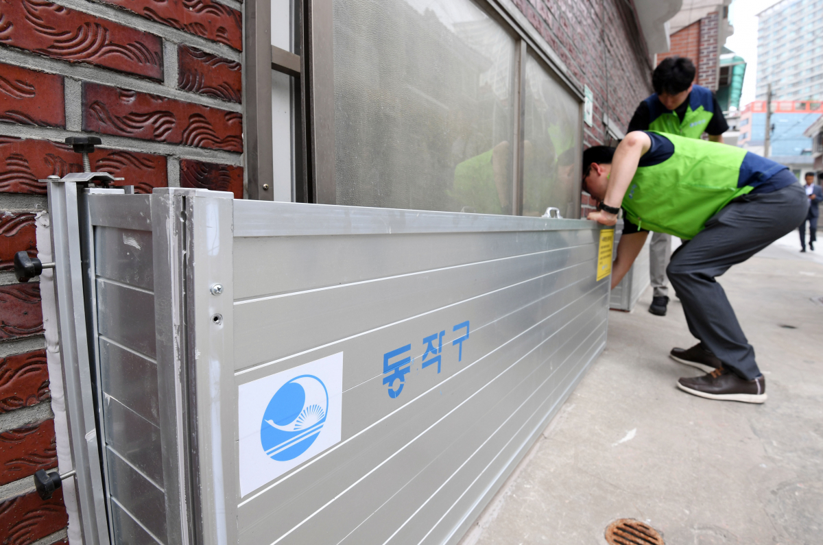 ▲본격적인 장마를 앞둔 23일 서울 동작구 도림천 인근 저지대 주택가에서 동작구청 관계자들이 설치된 수해예방용 물막이판을 점검하고 있다. 신태현 기자 holjjak@