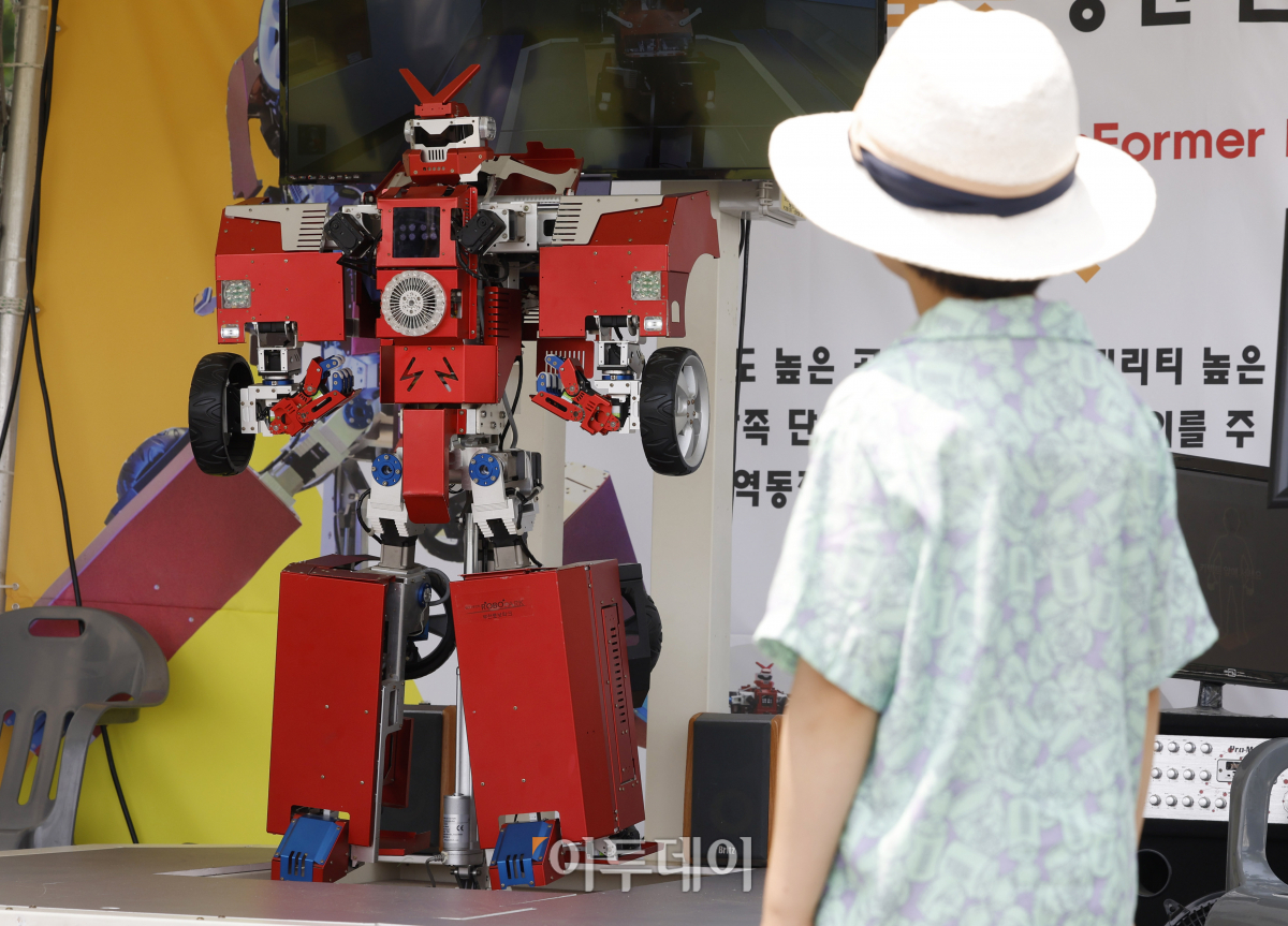 ▲25일 서울 용산구 용산어린이정원에서 열린 로봇과 함께하는 어린이 체험 페스티벌 '로봇 그리고 인간:로봇과놀자'를 찾은 한 아이가 변신로봇을 살펴보고 있다. 조현호 기자 hyunho@