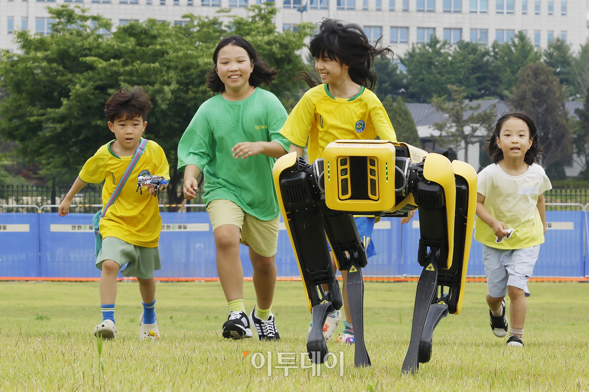 ▲25일 서울 용산구 용산어린이정원에서 열린 로봇과 함께하는 어린이 체험 페스티벌 '로봇 그리고 인간:로봇과놀자'를 찾은 아이들이 4족보행 로봇과 뛰어놀고 있다. 조현호 기자 hyunho@