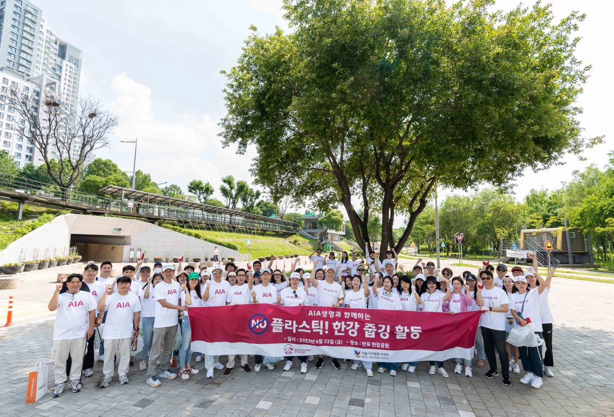 ▲AIA생명이 지난 23일 반포 한강공원 일대에서 ‘노 플라스틱 한강 줍깅 행사’를 진행했다. 행사에 참여한 AIA생명 임직원 70여명이 단체 사진을 촬영하고 있다.