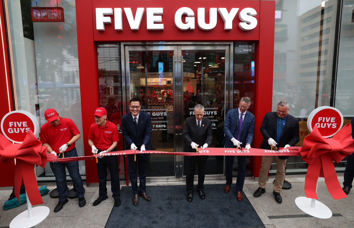 ▲미국 햄버거 브랜드 파이브가이즈의 국내 1호점 오픈일인 26일 서울 서초구 파이브가이즈 강남 앞에서 김동선(왼쪽 두번째) 한화갤러리아 전략본부장과 필립 골드버그(왼쪽 세 번째) 주한미국대사 등이 테이프 커팅을 하고 있다. 1986년 미국 버지니아에서 시작한 파이브가이즈는 2002년 해외진출 이래 현재 23개 국가에서 1800여개 매장을 운영 중이며 한국은 아시아 내 6번째다. 신태현 기자 holjjak@