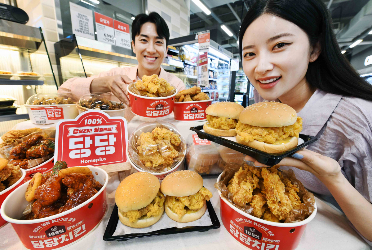 ▲모델들이 27일 서울 등촌동 ‘홈플러스 메가푸드마켓’ 강서점에서 신메뉴 ‘당당 순살치킨 트윈버거’와 ‘당당 후라이드 순살치킨’을 소개하고 있다. (사진제공=홈플러스)