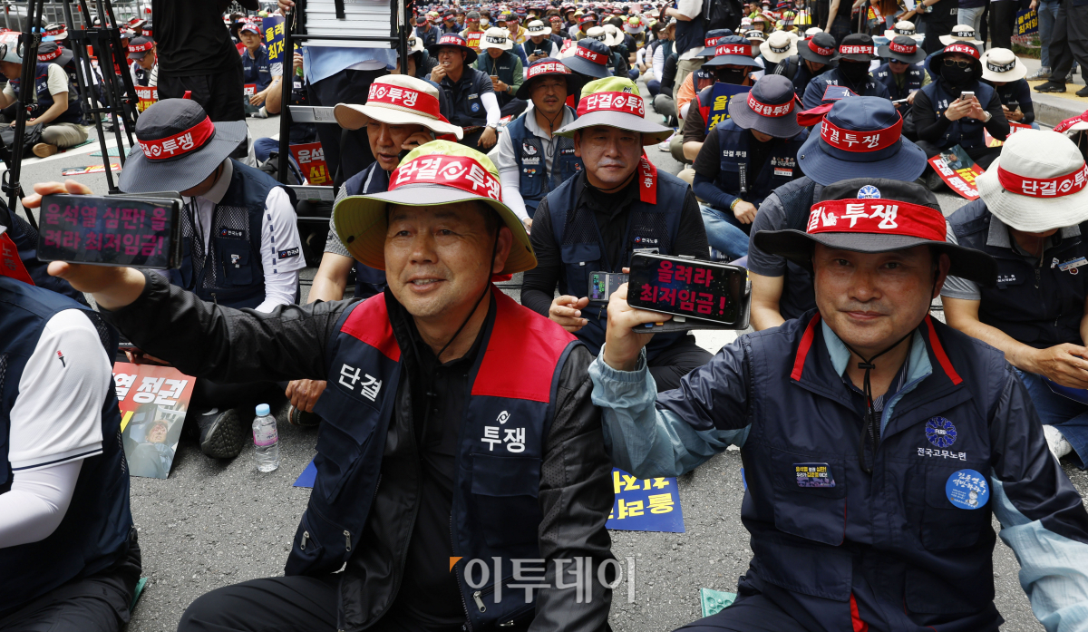 ▲27일 서울 중구 시청역 앞에서 열린 '윤석열 정권 심판! 최저임금 인상! 한국노총 노조간부 결의대회'에서 한국노총 조합원들이 핸드폰 문구 어플로 적은 '윤석열 심판! 올려라 최저임금' 피켓을 들고 구호를 외치고 있다. 조현호 기자 hyunho@