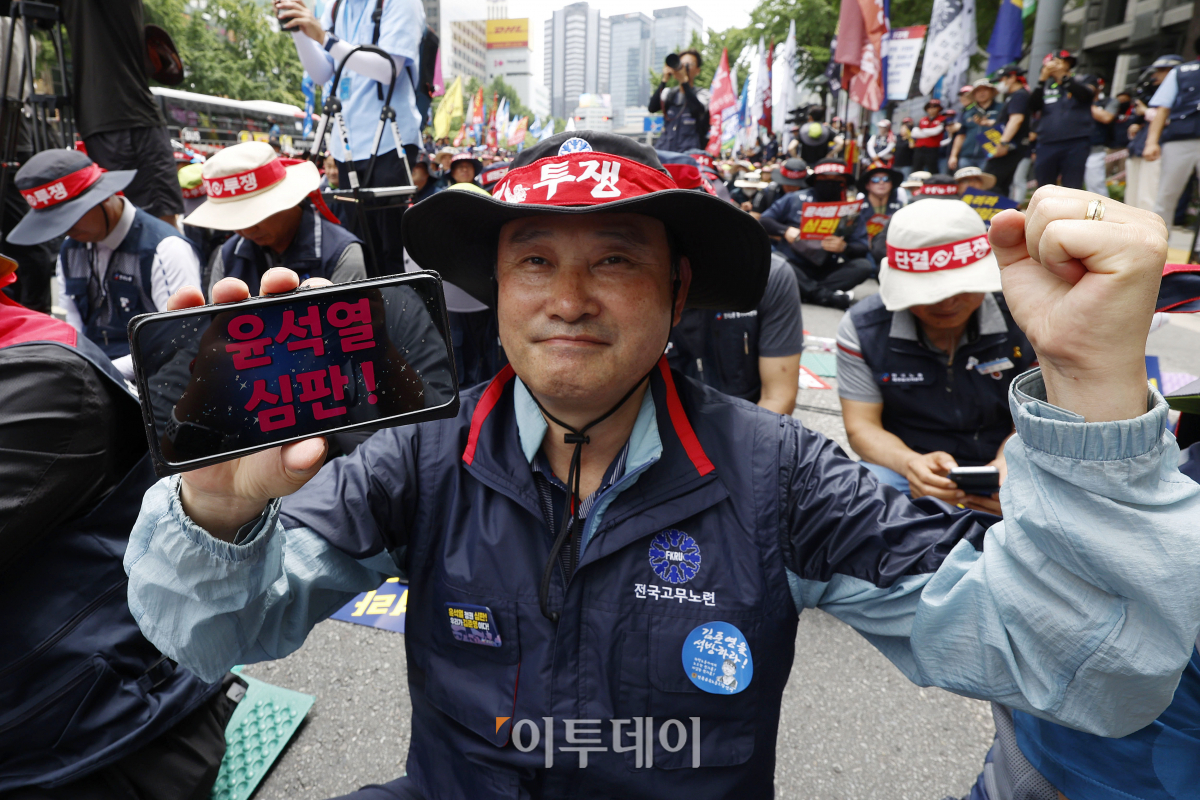 ▲27일 서울 중구 시청역 앞에서 열린 '윤석열 정권 심판! 최저임금 인상! 한국노총 노조간부 결의대회'에서 한국노총 조합원이 핸드폰 문구 어플로 적은 '윤석열 심판!' 피켓을 들고 구호를 외치고 있다. 조현호 기자 hyunho@