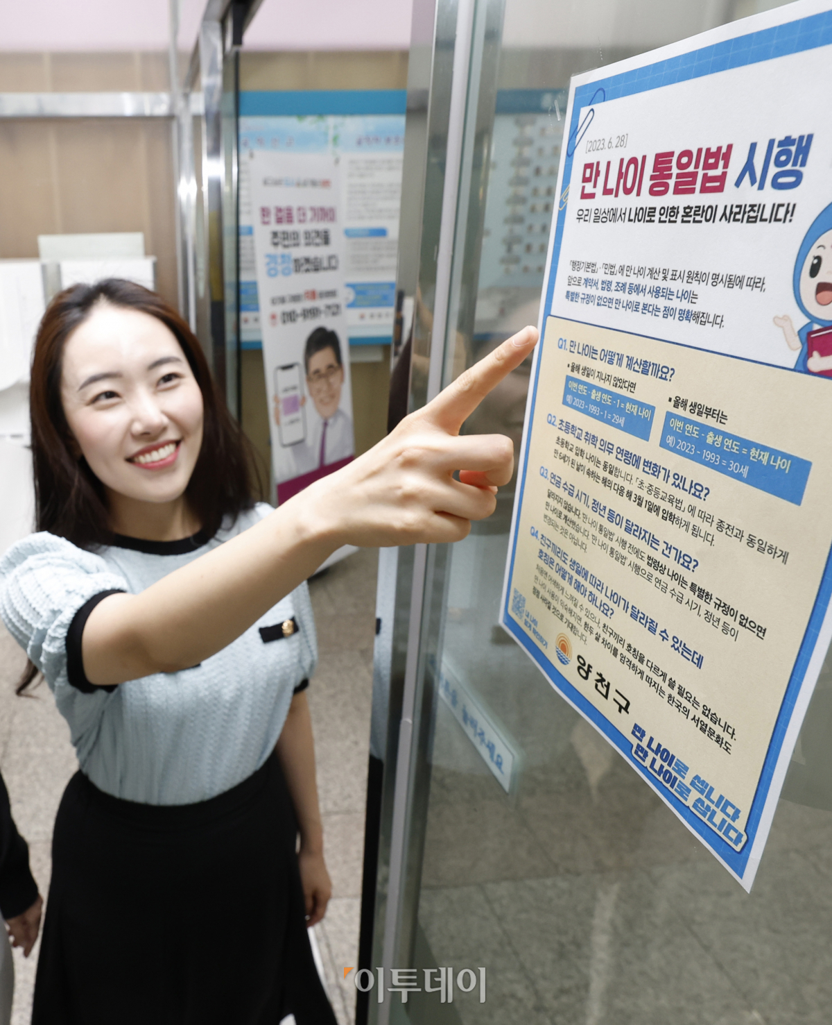 ▲만 나이 통일법 시행을 하루 앞둔 27일 서울 양천구 양천구청에서 시민들이 만 나이 통일법 시행 안내문을 살펴보고 있다. 28일부터 법적·사회적 나이를 만 나이로 적용하는 '만 나이 통일법'이 시행된다. 만 나이 통일법이 시행되면 생일을 기준으로 계산하게 된다. 조현호 기자 hyunho@