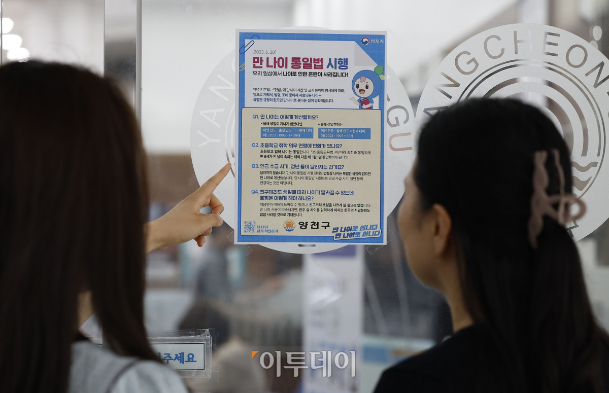 ▲만 나이 통일법 시행을 하루 앞둔 27일 서울 양천구 양천구청에서 시민들이 만 나이 통일법 시행 안내문을 살펴보고 있다. 28일부터 법적·사회적 나이를 만 나이로 적용하는 '만 나이 통일법'이 시행된다. 만 나이 통일법이 시행되면 생일을 기준으로 계산하게 된다. 조현호 기자 hyunho@