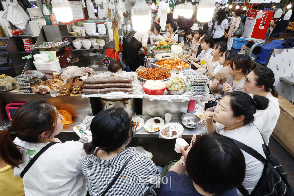 ▲소비자심리지수(CCSI)가 13개월만에 장기 평균치를 상회한 것으로 나타났다. 28일 한국은행이 발표한 '6월 소비자동향조사 결과'에 따르면 이달 소비자심리지수는 100.7로 전월 대비 2.7포인트 상승했다. 지수 수준이 4개월 연속 오름세에 지수가 100을 웃돈 것은 작년 5월(102.9) 이후 13개월 만에 처음이다. 이날 서울 종로구 광장시장을 찾은 시민들이 포장마차 음식을 먹고 있다. 조현호 기자 hyunho@