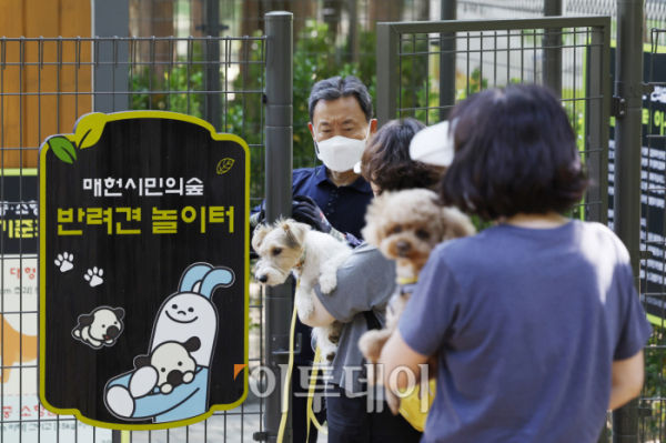 ▲'매헌시민의숲 반려견놀이터'가 한 달간의 시범운영을 시작한 13일 서울 서초구 매헌시민의숲 반려견놀이터를 찾은 시민들과 반려견들이 반려견놀이터에 입장하고 있다. 조현호 기자 hyunho@