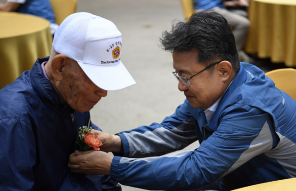 ▲포스코이앤씨 한성희 사장이 6.25 참전 어르신께 꽃을 달아 드리고 있다(사진제공=포스코이앤씨)