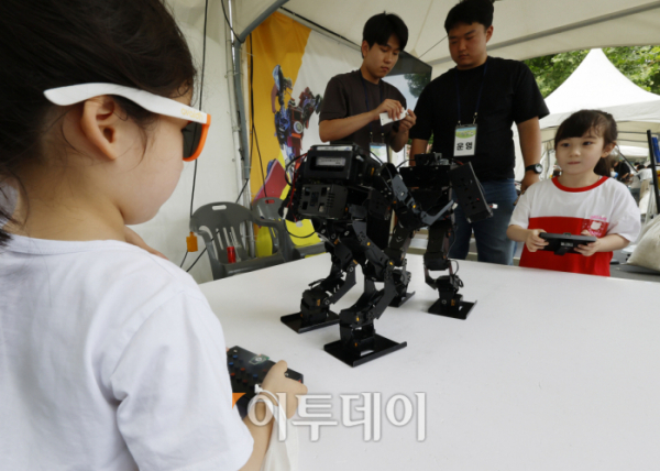 ▲25일 서울 용산구 용산어린이정원에서 열린 로봇과 함께하는 어린이 체험 페스티벌 '로봇 그리고 인간:로봇과놀자'를 찾은 아이들이 휴머노이드 조종 체험을 하고 있다. 조현호 기자 hyunho@