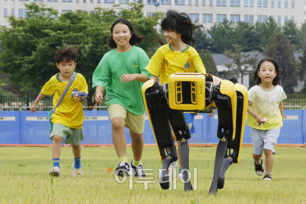 ▲25일 서울 용산구 용산어린이정원에서 열린 로봇과 함께하는 어린이 체험 페스티벌 '로봇 그리고 인간:로봇과놀자'를 찾은 아이들이 4족보행 로봇과 뛰어놀고 있다. 조현호 기자 hyunho@