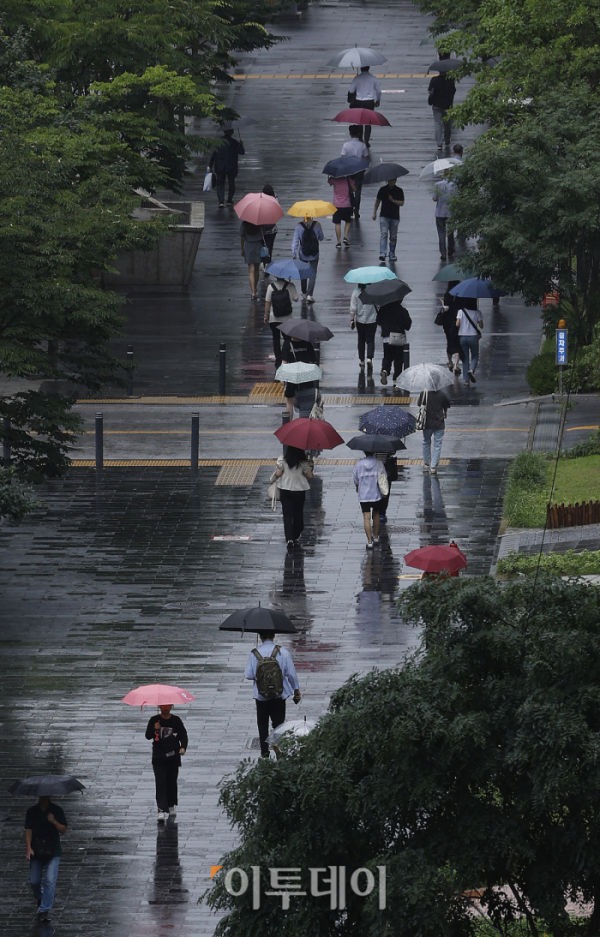 ▲장맛비가 내리는 26일 서울 영등포구 여의도역 일대에서 우산을 쓴 시민들이 출근길 발걸음을 재촉하고 있다. 조현호 기자 hyunho@