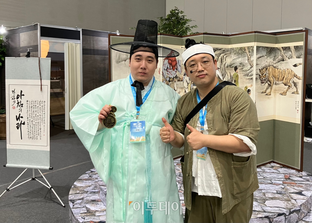 ▲1일 수원 컨벤션센터에서 열린 '검은사막 페스타'에서 트위치 크리에이터 박대봉(사진 왼쪽)과 팔도대왕이 '아침의 나라' 부스 체험 후 기념 사진 촬영을 하고 있다. (임유진 기자 newjean@)