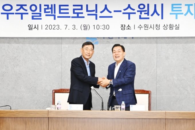 ▲이재준 수원시장(오른쪽)과 노영백 ㈜우주일렉트로닉스 회장이 '본사와 연구소 이전을 위한 투자 협약'을 맺은 후 손을 맞잡고 있다. (수원시)