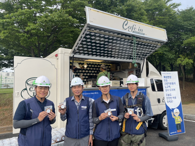 ▲현대엔지니어링 현장 직원들이 'HEC心 Delivery' 캠페인을 통해 준비된 간식차 앞에서 기념촬영을 하고 있다. (사진제공=현대엔지니어링)