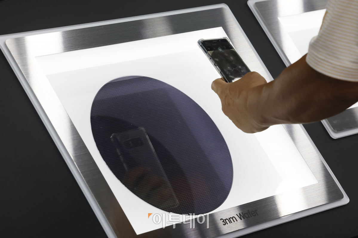 ▲5일 경기도 고양시 킨텍스에서 열린 '제21회 국제나노기술 심포지엄 및 융합전시회·아템페어 2023' 삼성전자 부스에서 관람객이 3나노 웨이퍼를 살펴보고 있다. 조현호 기자 hyunho@