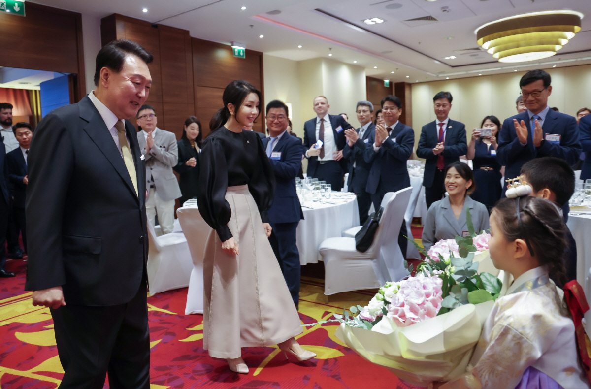 ▲폴란드를 공식 방문한 윤석열 대통령과 김건희 여사가 12일(현지시간) 바르샤바 한 호텔에서 열린 동포간담회에서 화동으로부터 꽃다발을 받고 있다. (연합뉴스)