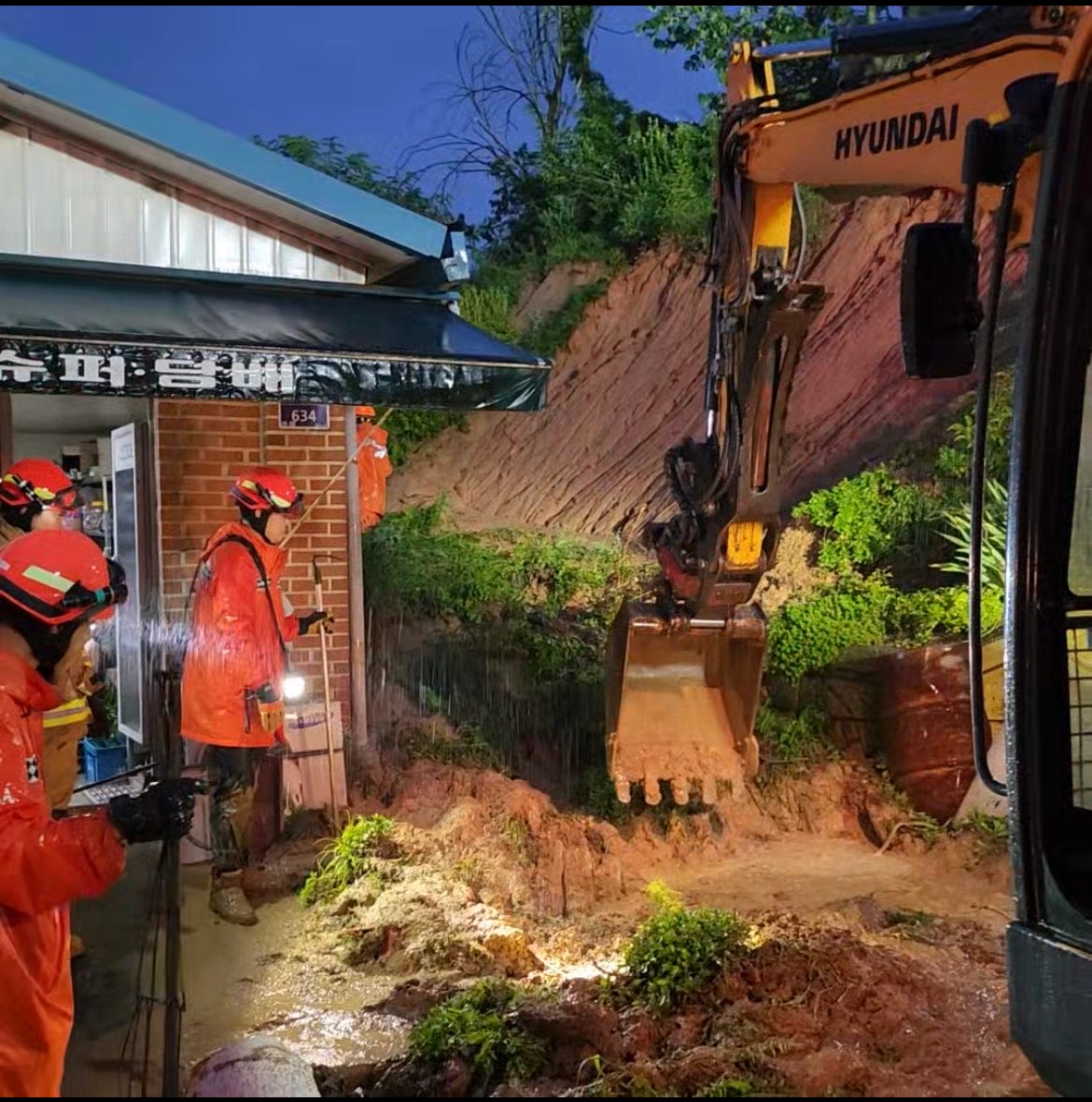 ▲15일 오전 4시 53분께 세종시 연동면 송용리 한 야산 비탈면에서 쏟아진 토사물이 인근 단독주택 앞을 덮쳐 소방대원들이 토사물을 정리하고 있다. 이 사고로 70대 주민 1명이 매몰돼 심정지 상태로 구조됐다. (연합뉴스)