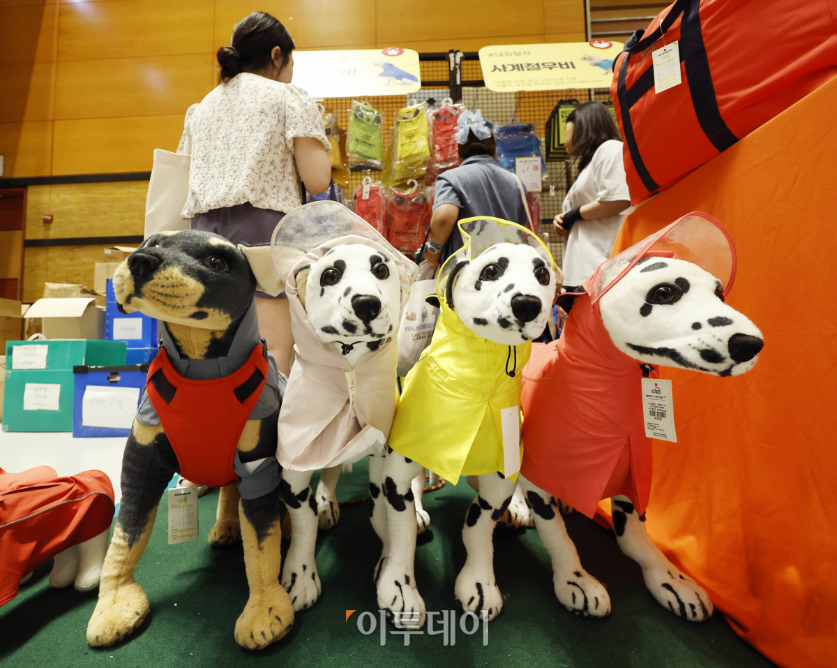 ▲21일 서울 강남구 코엑스에서 열린 '2023 케이펫페어'에서 관람객들이 반려견용 우비를 살펴보고 있다. 조현호 기자 hyunho@