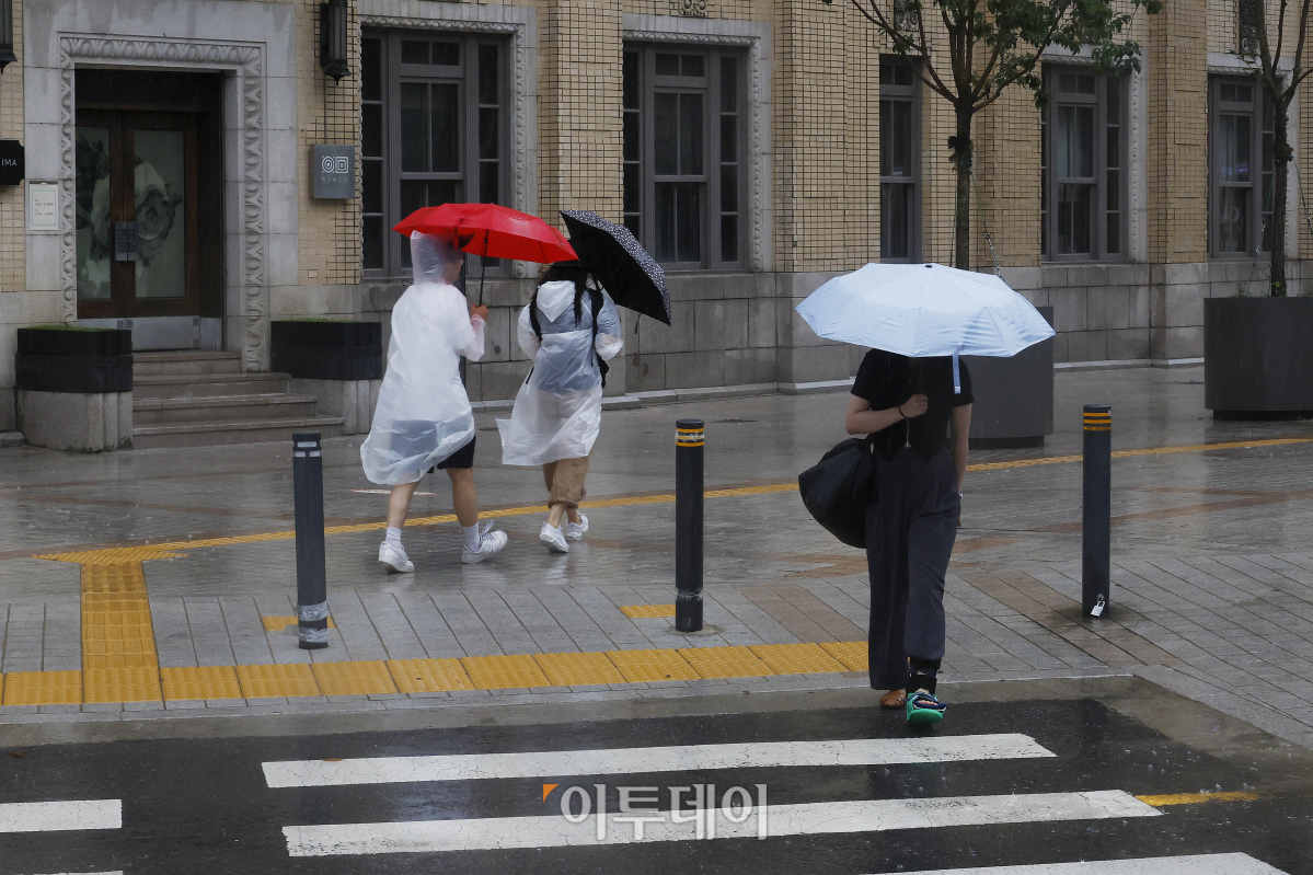 ▲1년 중 가장 덥다는 절기상 대서인 23일 오전 서울 종로구 광화문역 일대에서 우산을 쓴 시민들이 발걸음을 재촉하고 있다. 기상청은 이날 오전 6시를 기해 서울 전역에 호우주의보를 발령하고 중부지방과 전라권을 중심으로 최대 120mm 이상의 많은 비가 내릴 것으로 예보했다. 조현호 기자 hyunho@