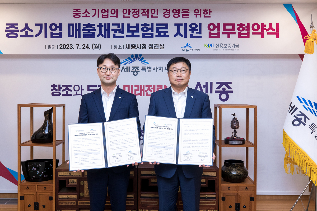 ▲심현구 신용보증기금 전무이사(왼쪽), 이승원 세종시 경제부시장(오른쪽)이 24일 세종시청에서 열린 ‘매출채권보험 보험료 지원 업무협약’에 참석해 기념 촬영을 하고 있다. (사진제공=신용보증기금)