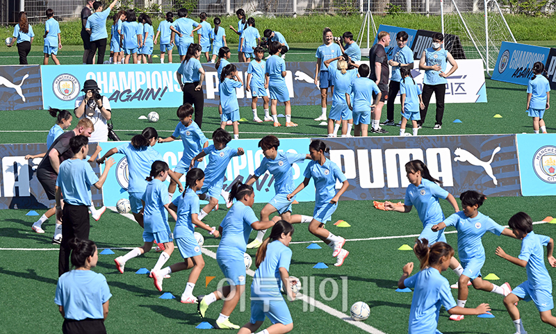 ▲29일 상암 월드컵경기장 보조구장에서 열린 유소년 축구교실에서 맨체스터 시티 코치진들이 여자 축구 꿈나무들에게 드리블 등 기초 기술과 기본 훈련방법에 대해서 강연하고 있다. 사진공동취재단