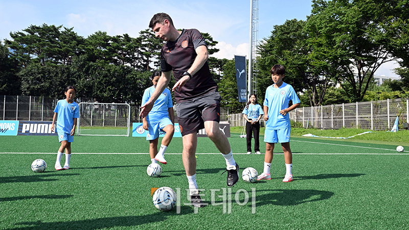 ▲29일 상암 월드컵경기장 보조구장에서 열린 유소년 축구교실에서 맨체스터 시티 코치진들이 여자 축구 꿈나무들에게 드리블 등 기초 기술과 기본 훈련방법에 대해서 강연하고 있다. 사진공동취재단