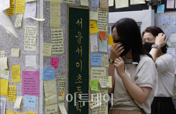 ▲신규교사가 극단적 선택을 한 서울 서초구 서이초등학교 앞에서 열린 추모행사에서 추모객들이 교문 외벽에 추모 메세지를 붙이고 있다.  (이투데이DB)