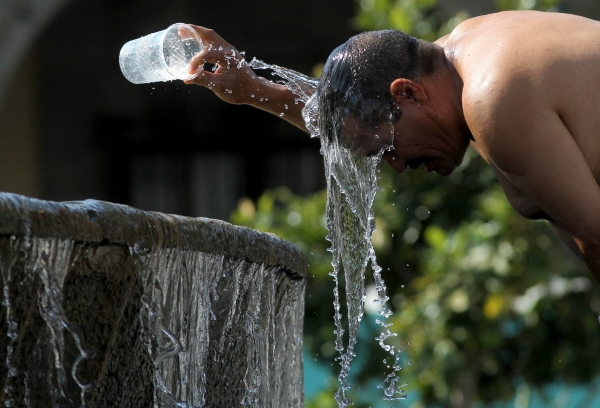 ▲멕시코 과달라하라에서 12일(현지시간) 한 시민이 머리에 물을 부으며 열을 식히고 있다. 과달라하라(멕시코)/AFP연합뉴스
