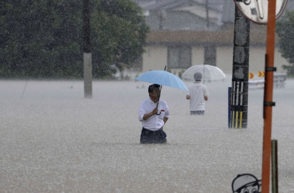 ▲10일 일본 남부 후쿠오카현 구루메에서 주민들이 폭우로 침수된 도로를 힘겹게 지나고 있다. 일본 남서부 지역에 폭우가 쏟아지면서 홍수와 산사태가 발생했으며 일본 기상청은 규슈 남부 일부 지역에 호우경보를 발령했다. (AP/뉴시스)
