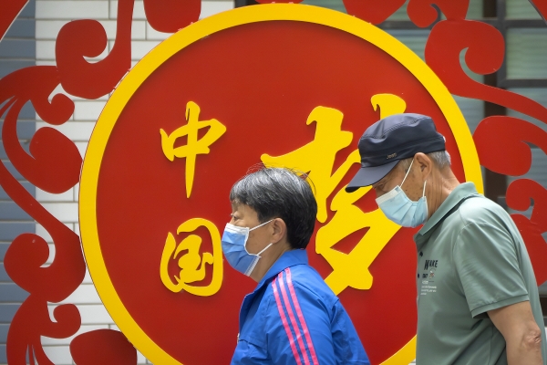 ▲2023년 5월 11일 중국 베이징의 한 공원에서 마스크를 쓴 사람들이 ‘중국몽’이라고 적힌 광고판 앞을 지나가고 있다. 베이징/AP뉴시스

