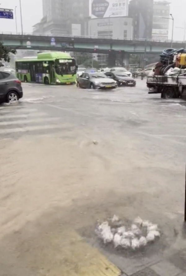 ▲거센 비가 쏟아진 13일 오후 서울 사당역 인근 도로에서 맨홀이 역류하고 있다.  (출처=트위터)
