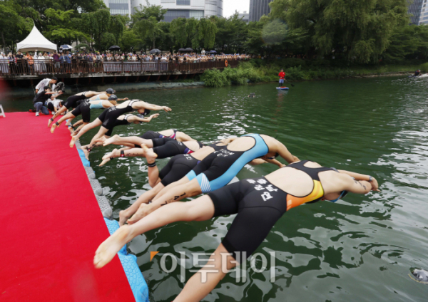 ▲16일 오전 서울 송파구 롯데월드타워 일대에서 열린 '2023 롯데 아쿠아슬론 대회'에 출전한 참가자들이 석촌호수에서 수영하고 있다. 작년에 이어 두 번째로 열리는 이번 대회는 석촌호수 수영과 롯데월드타워 수직 마라톤 스카이런(SKY RUN)으로 진행됐다. 조현호 기자 hyunho@