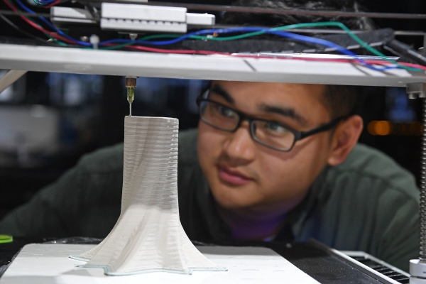 ▲중국 장시성 징더전의 한 3D 프린팅 기술업체 직원이 3D 프린팅 기계로 만들어지는 세라믹 꽃병을 살펴보고 있다. 징더전(중국)/신화뉴시스
