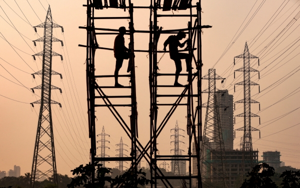 ▲인도 뭄바이의 송전탑 옆에서 근로자들이 작업하고 있다. 뭄바이(인도)/로이터연합뉴스 
