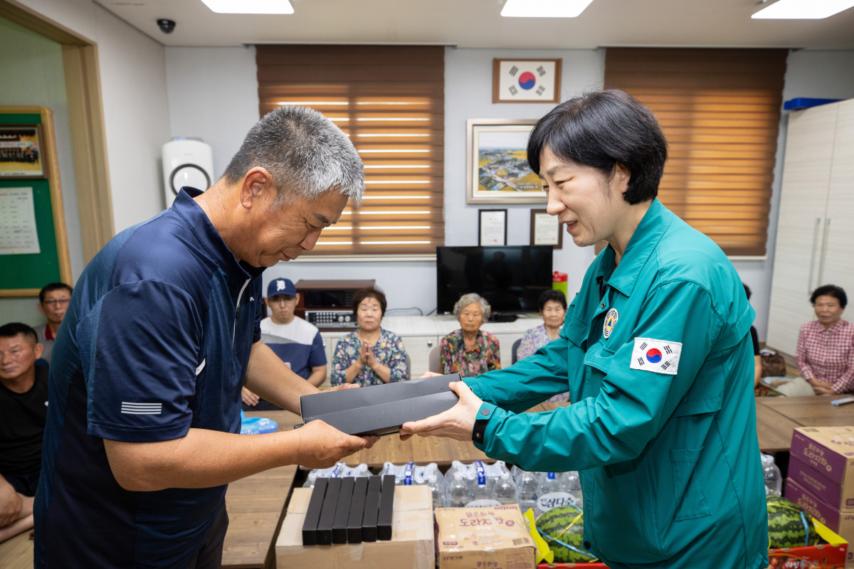 ▲한화진 환경부 장관이 7일 충남 논산시 무더위 쉼터를 찾아 폭염에 취약한 어르신에게 친환경 소재의 양우산, 손수건, 생수 등 폭염 대비 물품을 전달하고 있다. (사진제공=환경부)