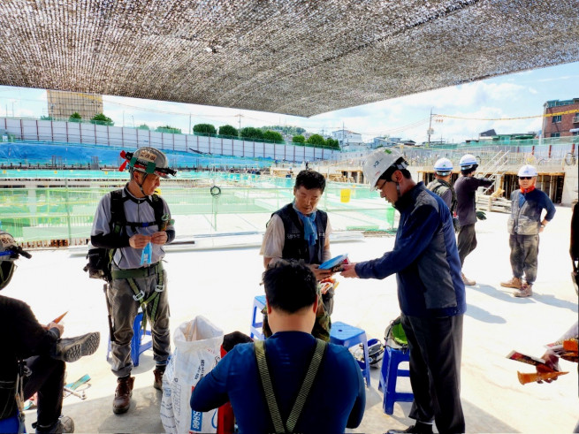 ▲(오른쪽)우무현 최고안전책임자(CSO)가 GS건설 8일 장위자이 레디언트 현장에 방문해 근로자들에게 빙과류를 제공하고 있다. (사진제공=GS건설)