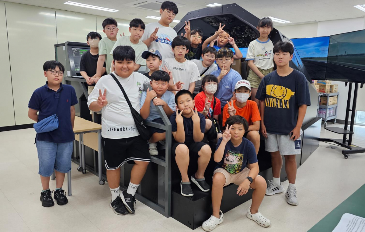 ▲항공우주산학융합원은 지난 17일 지혜공유학당과‘항공우주 꿈 찾기 체험 캠프’행사를 진행했다. B737 항공기 시뮬레이터 앞에서 체험하고 활짝 웃고 있는 학생들.
