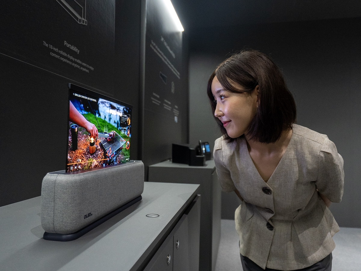 ▲23일 부산 벡스코에서 열린 ‘IMID 2023'에서 관람객이 LG디스플레이의 18인치 차량용 롤러블 OLED 패널을 살펴보고 있다. (사진제공=LG전자)