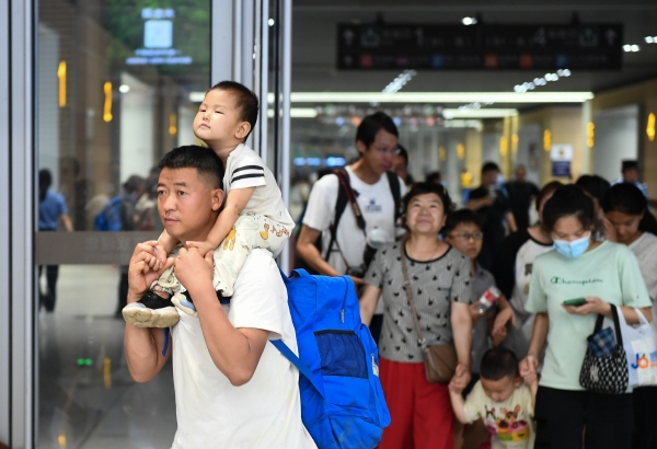 ▲중국 베이징에서 2일 남성이 아이를 목마 태운 채 기차역을 나서고 있다. 베이징/신화연합뉴스
