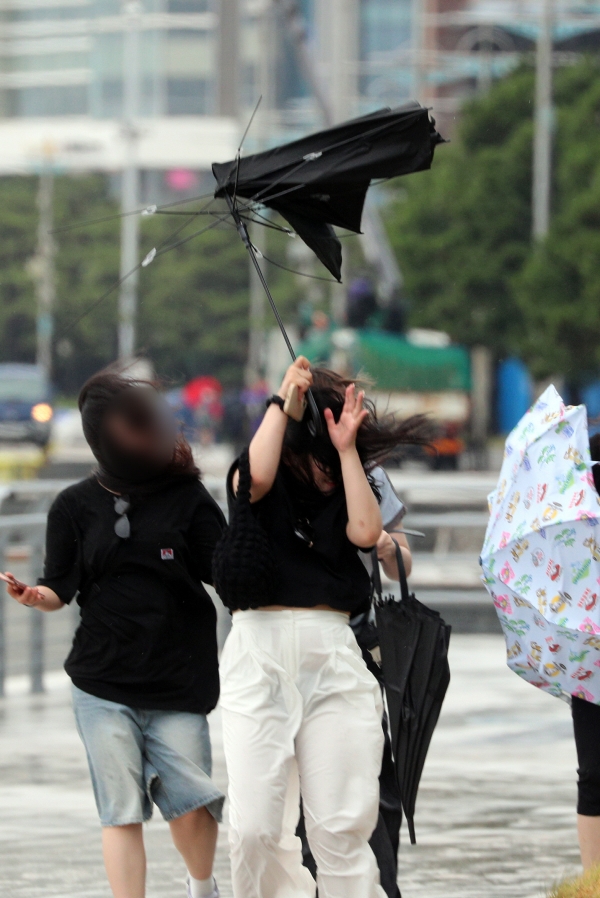 ▲6호 태풍 ‘카눈’의 영향권에 접어든 9일 오후 부산 해운대구 해운대해수욕장 엘시티 앞에서 시민들이 강풍을 동반한 비에 맞서 힘겹게 걸어가고 있다. (뉴시스)
