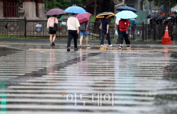 ▲전국이 제6호 태풍 카눈의 영향권에 든 10일 서울 세종로의 한 거리에서 우산을 쓴 시민들이 발걸음을 옮기고 있다. 신태현 기자 holjjak@