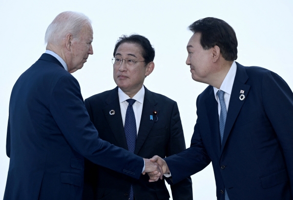 ▲윤석열(오른쪽) 대통령과 조 바이든(왼쪽) 미국 대통령, 기시다 후미오 일본 총리가 5월 21일 주요 7개국(G7) 정상회담장에서 인사하고 있다. 히로시마(일본)/AFP연합뉴스
