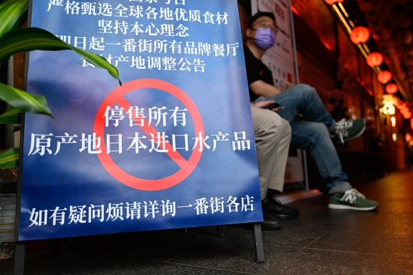 ▲중국 베이징의 한 일식당 앞에 27일 일본산 수산물의 판매를 중단한다는 내용이 적한 표지판이 세워져 있다. 베이징/AFP연합뉴스
